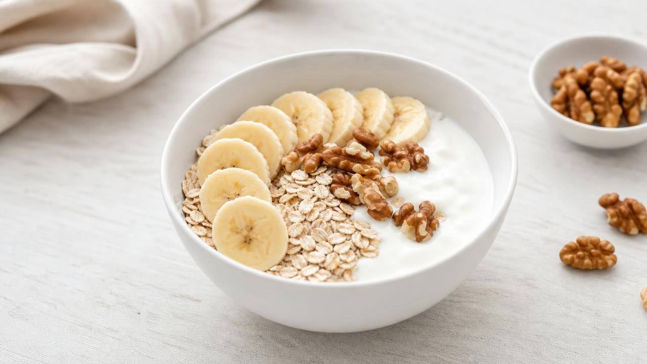 Banana fresca acompanhada de aveia e iogurte natural em mesa clara, representando uma alimentação equilibrada