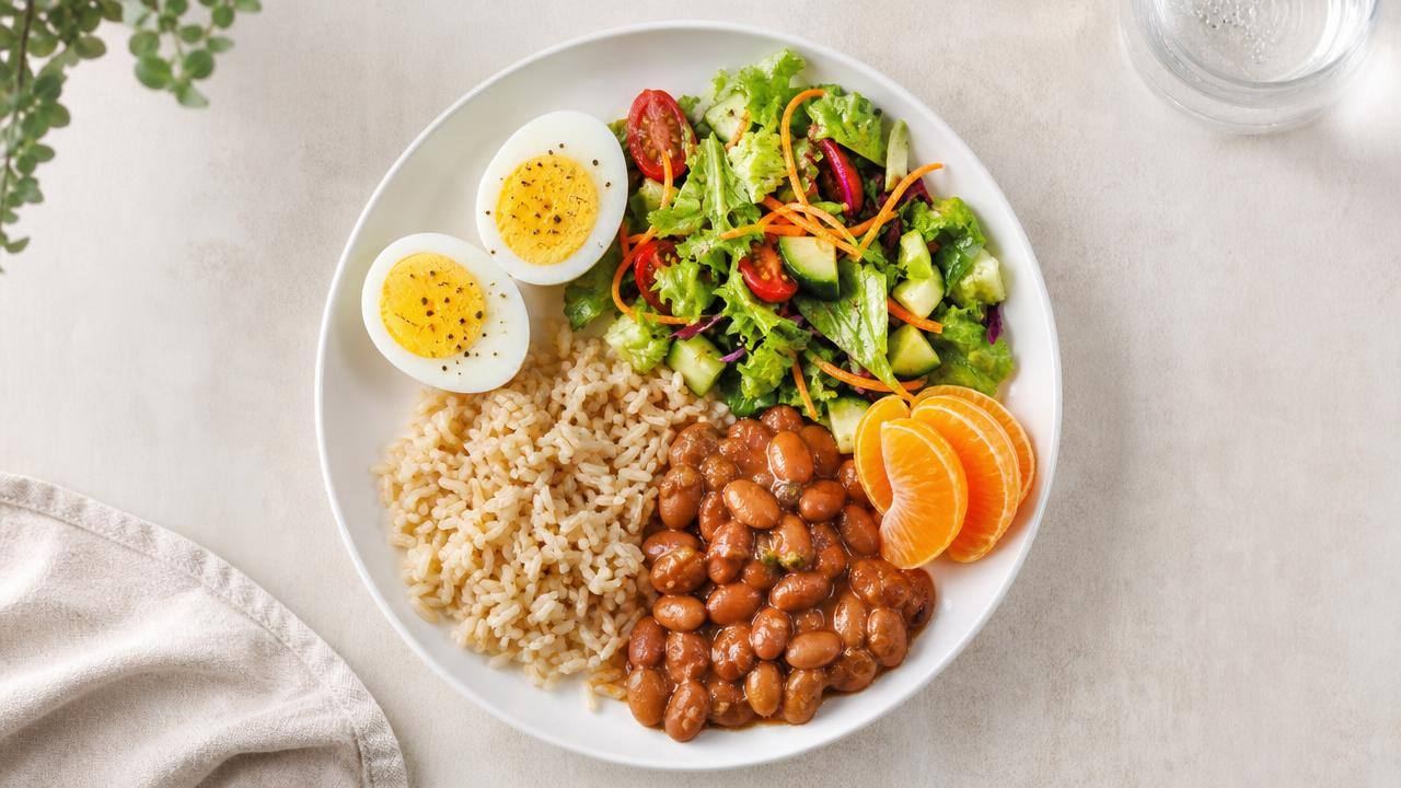 Ovos cozidos, salada colorida e alimentos naturais organizados em uma mesa clara