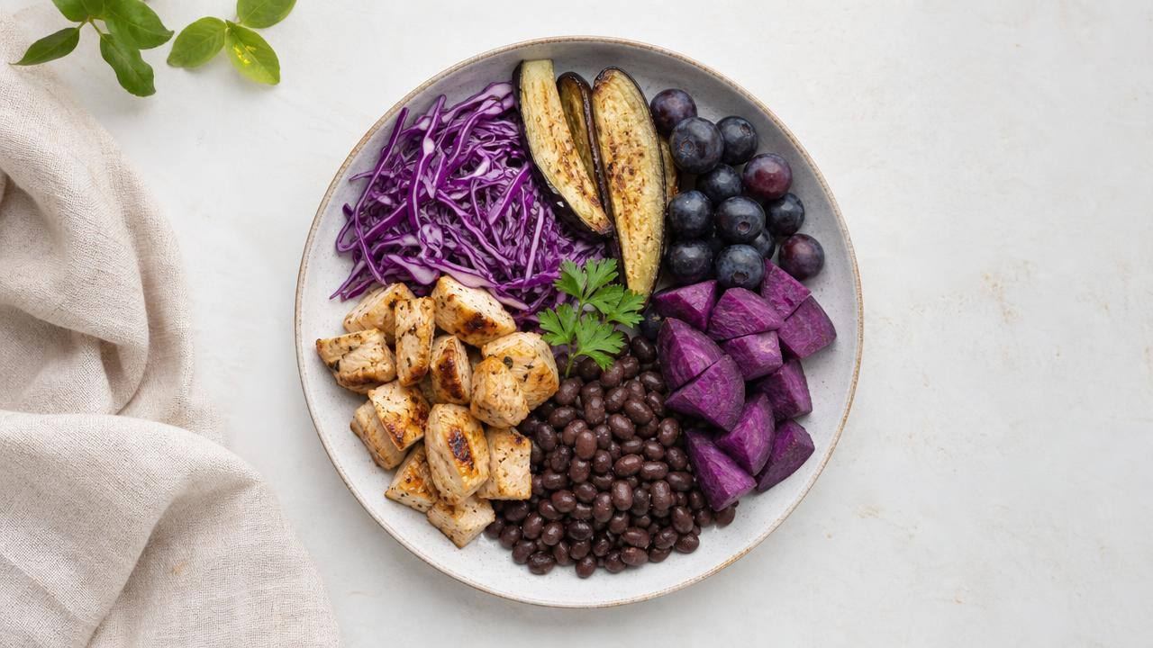 Prato equilibrado com repolho roxo, berinjela, uvas escuras e batata-doce roxa em composição limpa