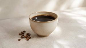 Ilustração de Xícara de café coado preto sobre mesa clara, em composição editorial minimalista
