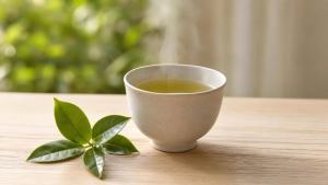 Ilustração de Xícara de chá verde quente sobre mesa clara, com folhas de Camellia sinensis ao lado