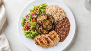 Prato equilibrado com berinjela assada, arroz, feijão, salada e proteína magra