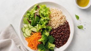 Prato equilibrado com salada, legumes frescos, arroz integral e feijão em composição clara e profissional