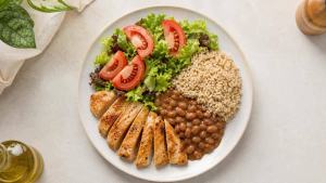 Prato equilibrado com salada de tomate, arroz integral, feijão e frango grelhado