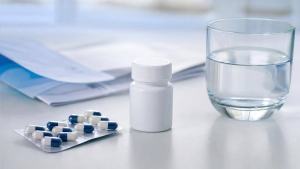 Ilustração de Cápsulas e cartela de medicamento em uma mesa clara, com foco em uso responsável de fluoxetina