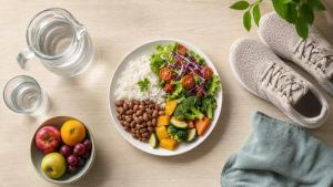 Ilustração de Pessoa organizando uma refeição equilibrada com legumes, frutas, água e grãos em uma mesa clara
