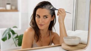 Ilustração de Pessoa aplicando uma máscara suave de argila no couro cabeludo para cuidar de cabelos oleosos
