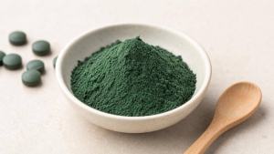 Ilustração de Pó verde-azulado de spirulina em pequena tigela sobre fundo claro, com composição limpa e editorial