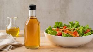 Ilustração de Frasco de vinagre de maçã ao lado de uma salada colorida em mesa clara
